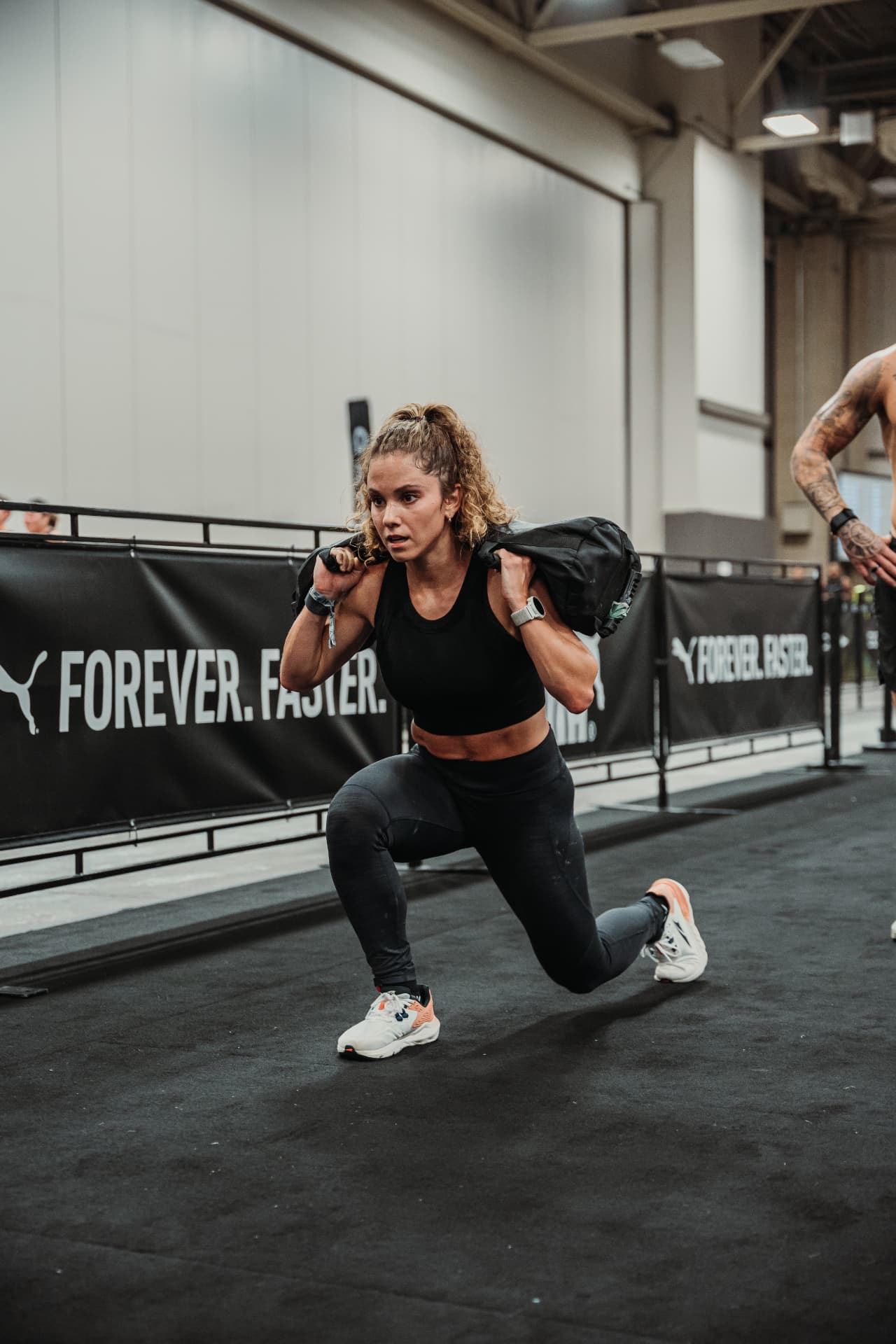 Erin competing with a weighted sandbag at HYROX Dallas